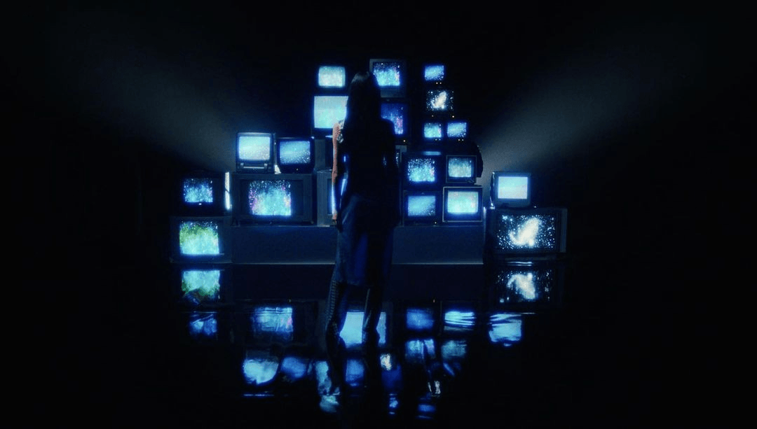 Person stood in front of a large number of CRT screens